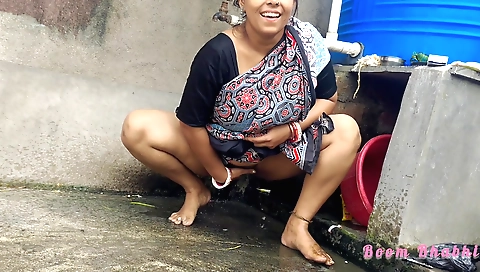Indian brunette peeing in the grass in front of the camera