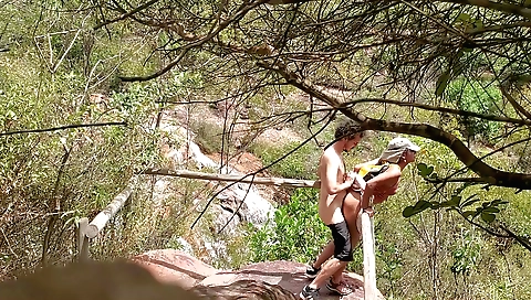A beautiful teen is getting wet in a waterfall in brazil